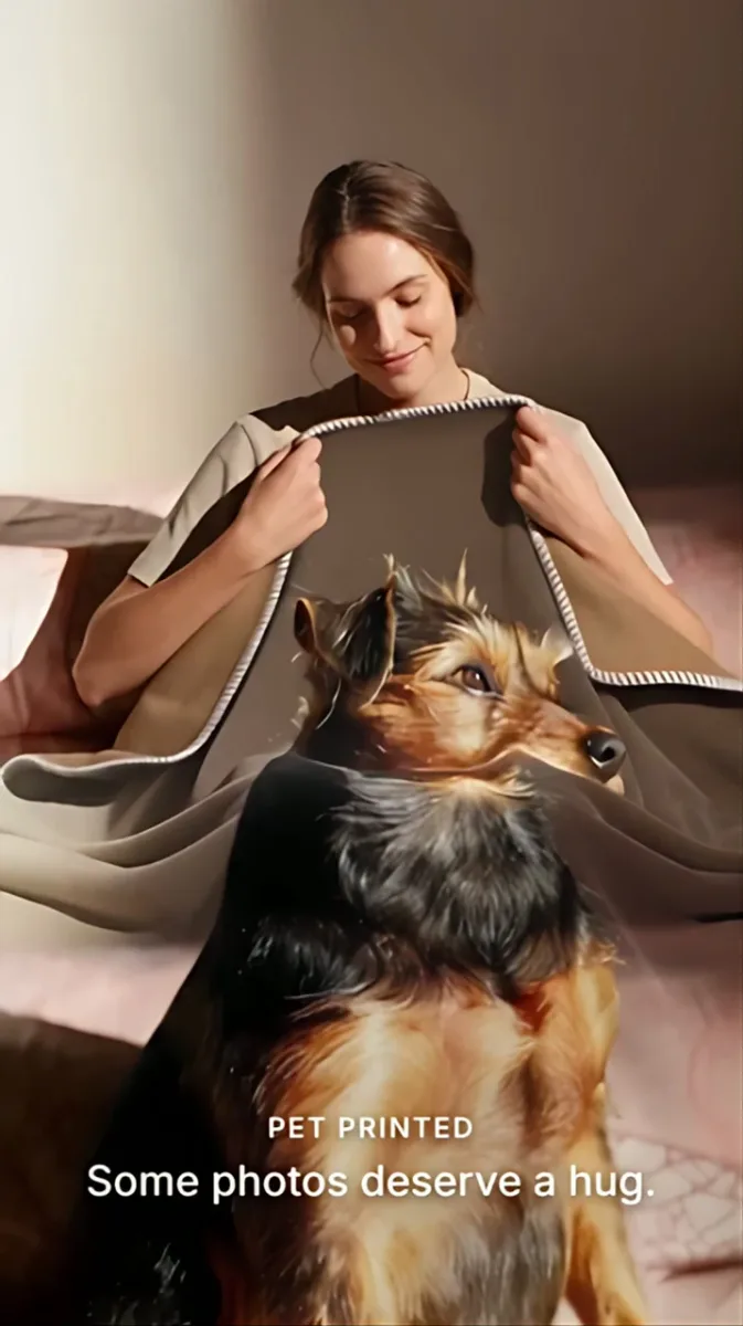 A person embracing a blanket printed with a dog portrait in warm light.